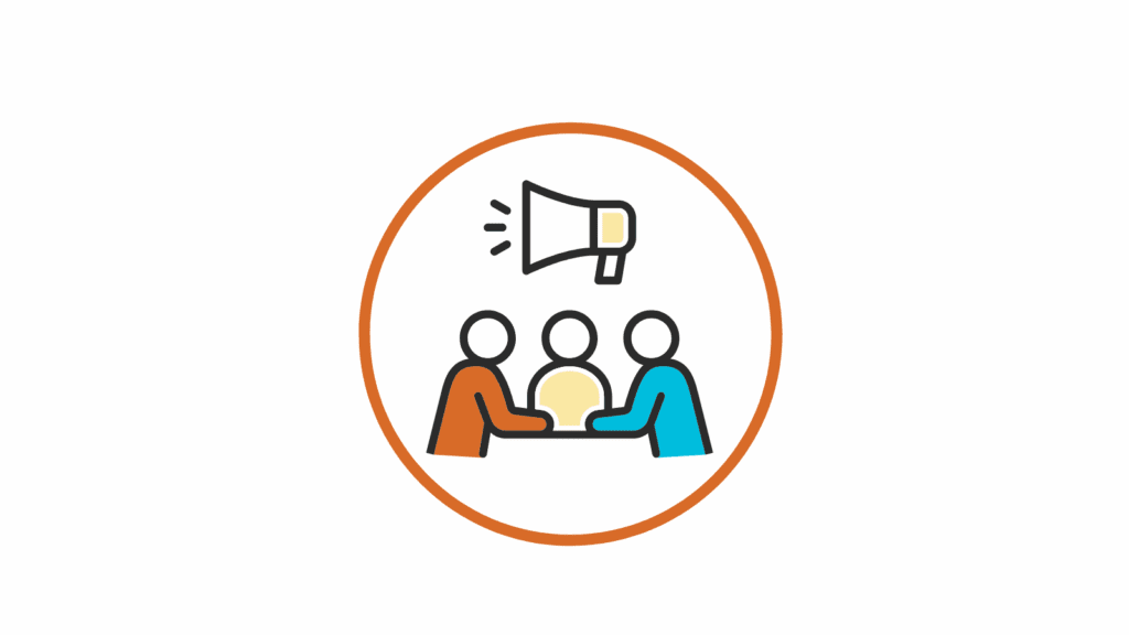 Icon of three simplified figures seated at a table, colored in orange, yellow, and blue. A megaphone is depicted above them, symbolizing communication, advocacy, or group discussion. The image is enclosed within an orange circle on a white background.
